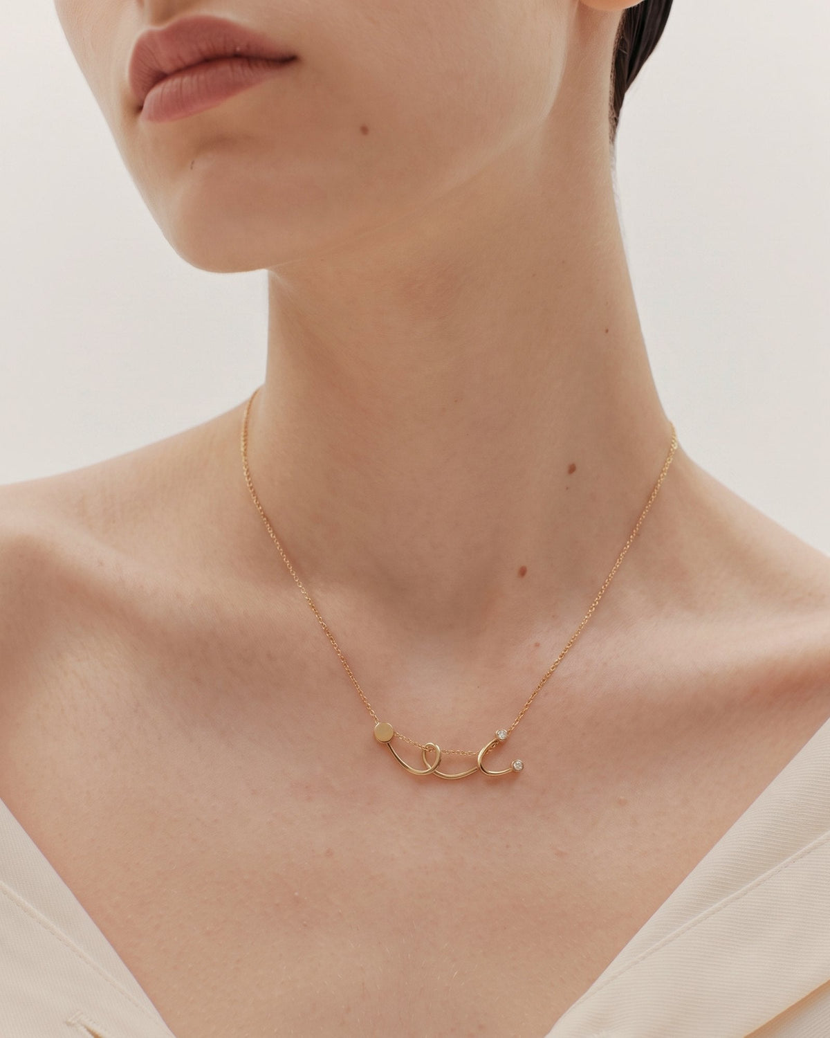 The Surya 18K gold stethoscope necklace with a diamond at each earpiece by House of Rednam