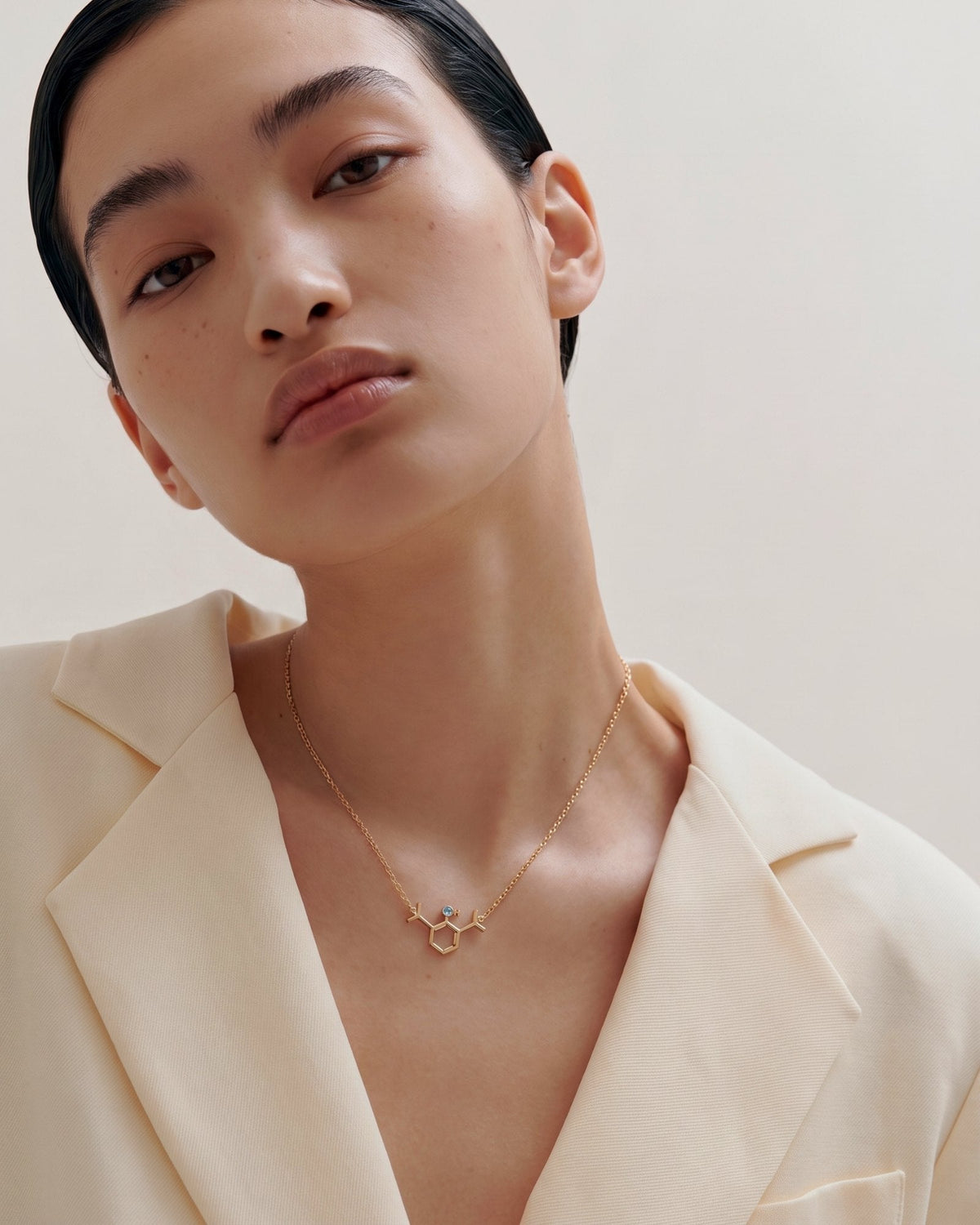 The Johanna 18K gold propofol molecule necklace with blue topaz by House of Rednam