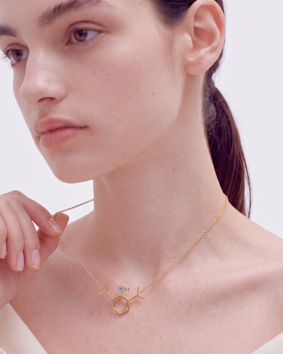 The Johanna 18K gold propofol molecule necklace with blue topaz by House of Rednam