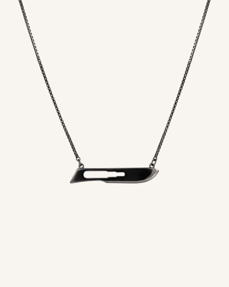 The Kiran scalpel necklace in 18K gold with black rhodium finish by House of Rednam