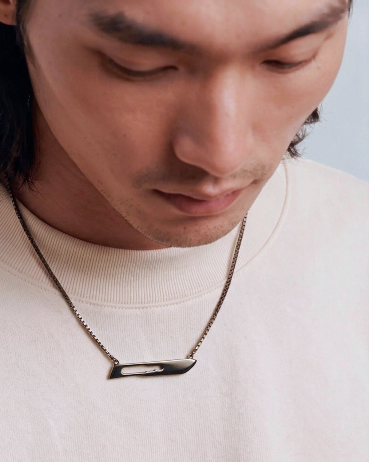 The Kiran scalpel necklace in 18K gold with black rhodium finish by House of Rednam