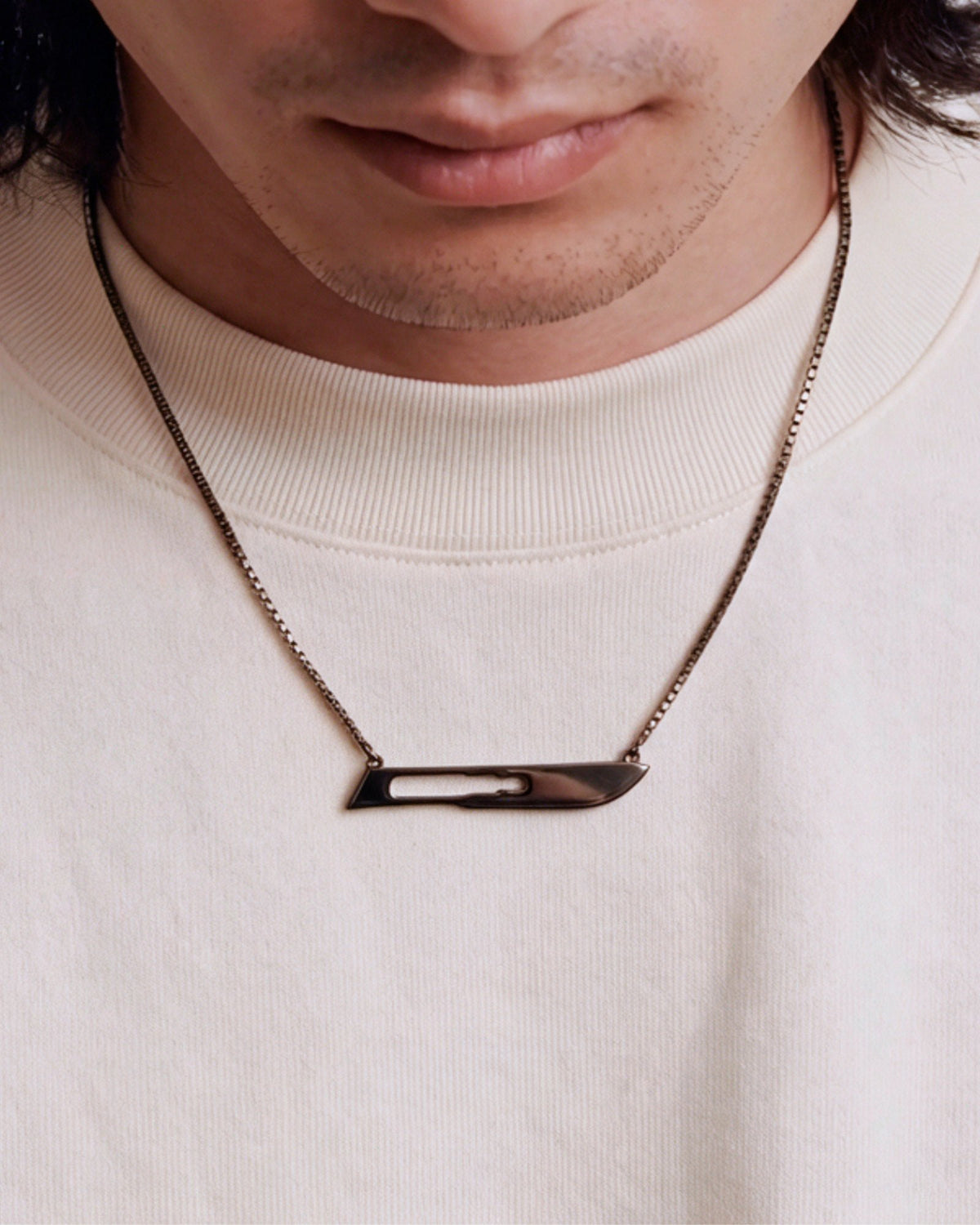 The Kiran scalpel necklace in 18K gold with black rhodium finish by House of Rednam