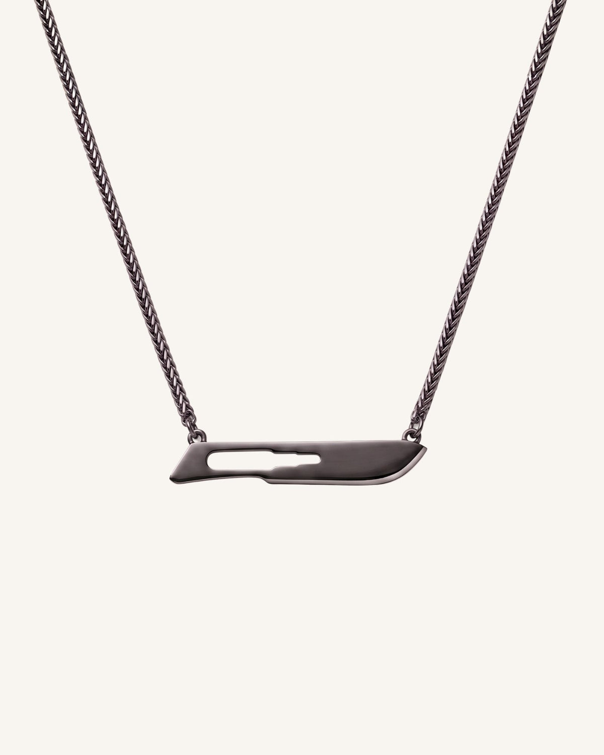 The Kiran No10 scalpel pendant in sterling silver with a black rhodium finish by House of Rednam