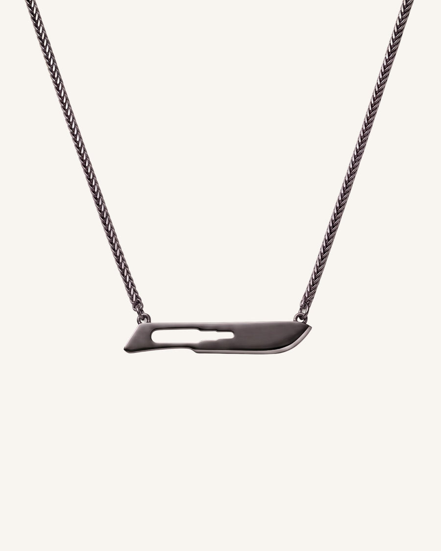 The Kiran No10 scalpel pendant in sterling silver with a black rhodium finish by House of Rednam