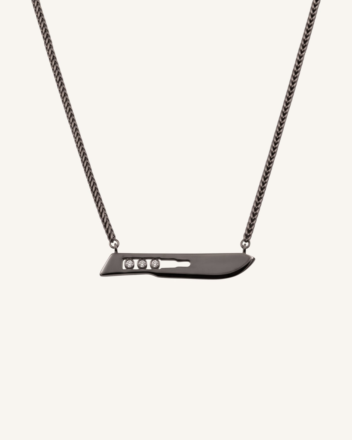 The Kiran No10 scalpel pendant in sterling silver with a black rhodium finish and three diamonds by House of Rednam