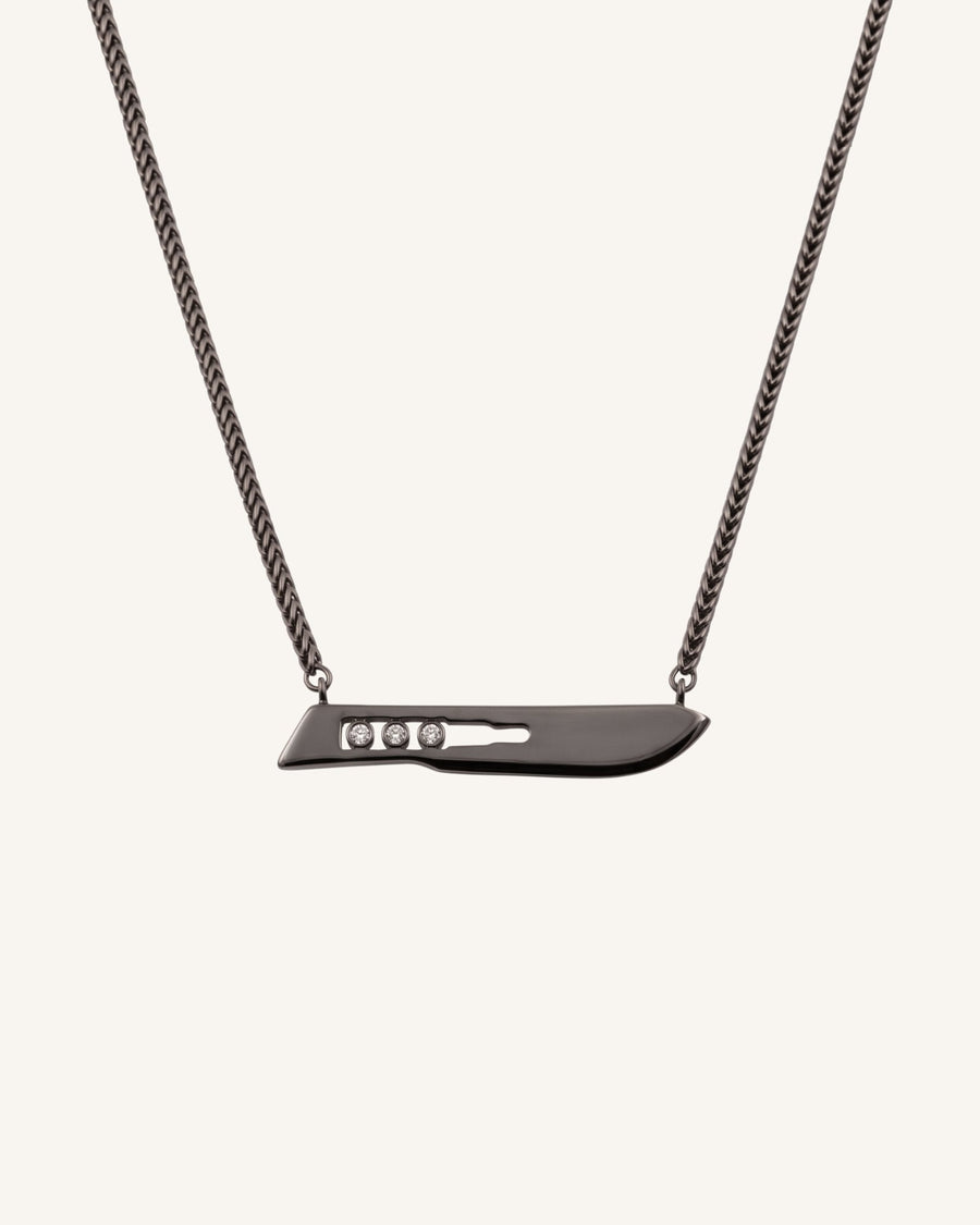 The Kiran No10 scalpel pendant in sterling silver with a black rhodium finish and three diamonds by House of Rednam