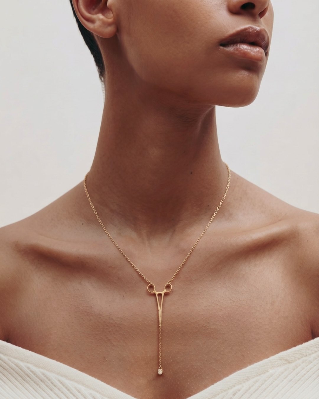 The Erin 18K yellow gold hemostat necklace with a diamond at the hinge by House of Rednam
